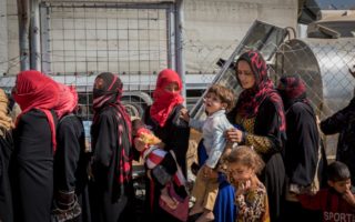 Displaced Iraqi women line up to receive food and water at Debaga camp for internally displaced people in Iraq’s Erbil Governorate.  © UNHCR/Ivor Prickett