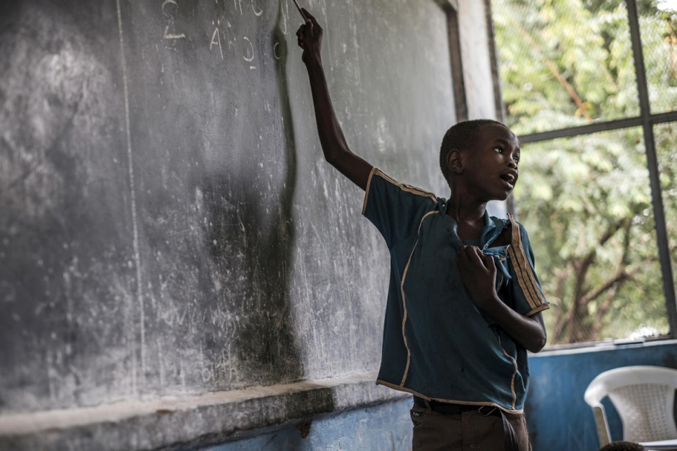 Boy points to something on a chalkboard in Ethiopia