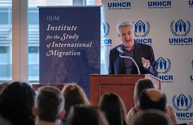 There is a man standing in front of a crowd. He is giving a speech.