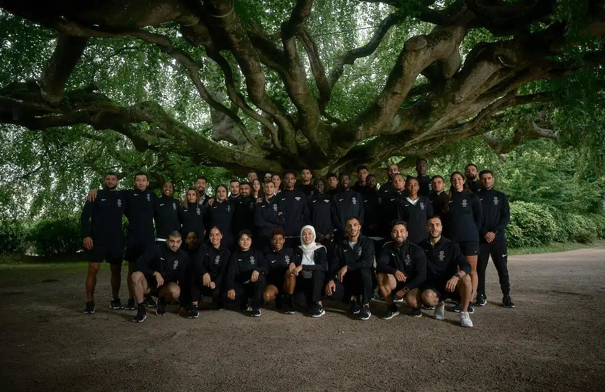 A large group of people are posing for a picture. They are dressed in all black sports clothes.