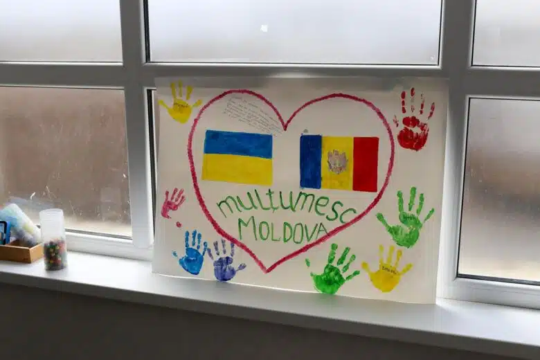 An art piece is displayed propped on a window sill. It pictures the Republic of Moldova's flag and the Ukrainian flag within a shared heart shape.