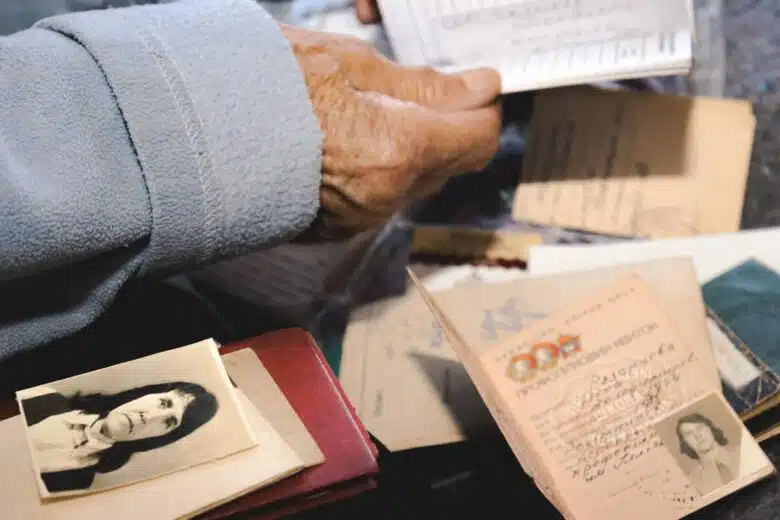 An elderly hand sorts through identity documents.